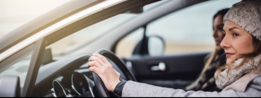 a female driving a car and another female passenger