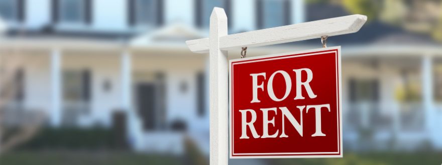 red for rent sign with properties behind