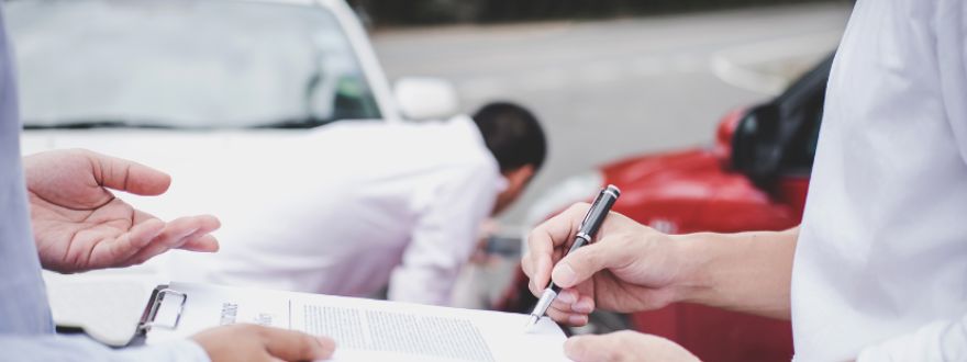 Florida driver reviewing personal injury protection (PIP) auto insurance policy with an insurance agent in Kendall at the accident scene.
