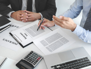 A driver reviewing official paperwork (DMV or insurance documents) SR-22 insurance filing in Florida for license reinstatement with an agent at American US Insurance
