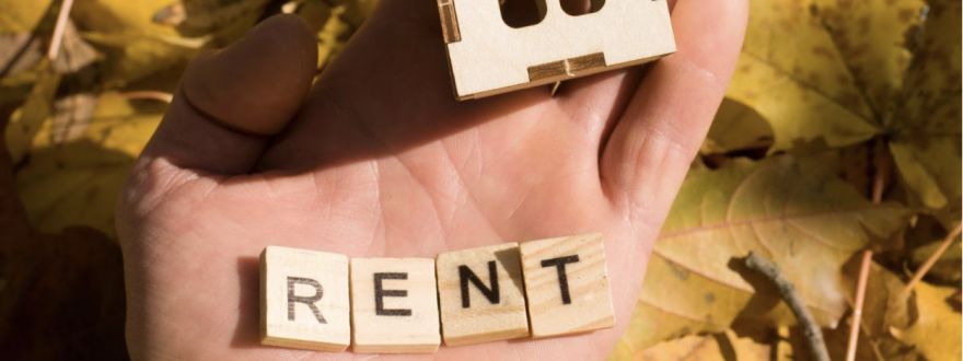 holding wooden blocks spelling out the word rent