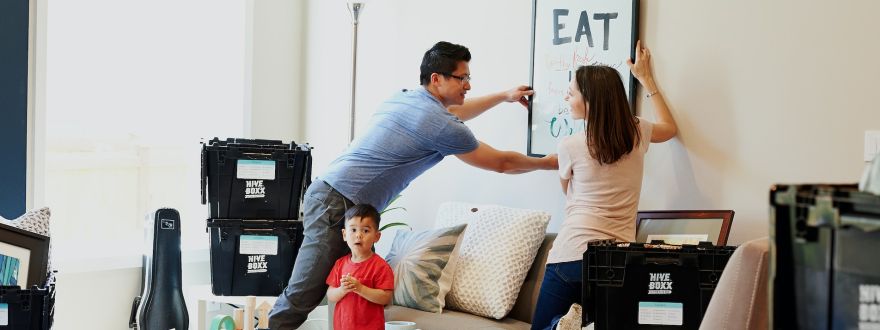 newly moved in couple putting up frame