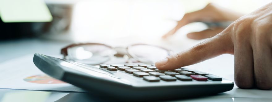 fingers typing on a calculator