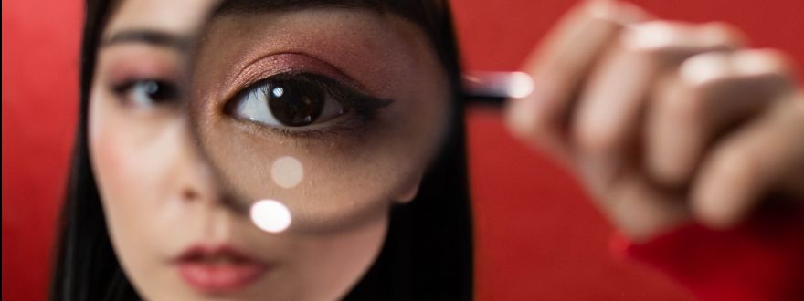 Woman looking through magnifying glass.