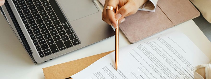 Picture of someone holding a pencil while reviewing a formal document.