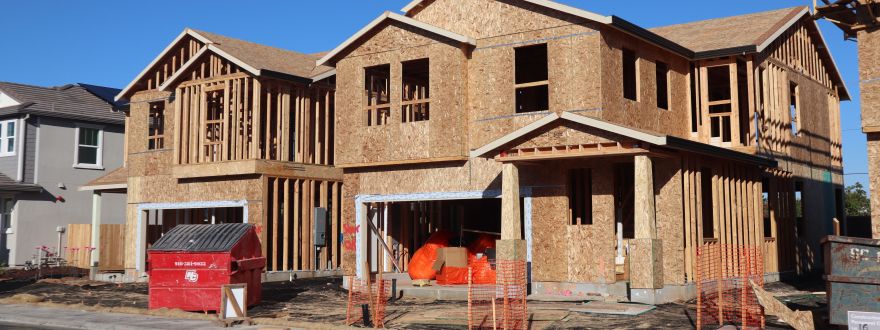 A photo of a 2-story frame built home under construction.