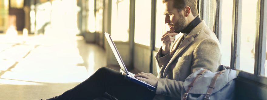 A man sitting on the floor working on a laptop