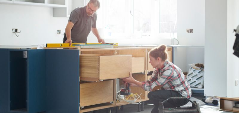 a team fitting a kitchen with contractor insurance 
