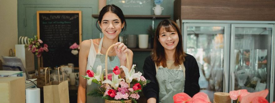 Smiling florists standing at counter in floristry shop