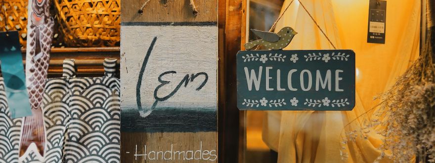 welcome sign hanging in front of the store door