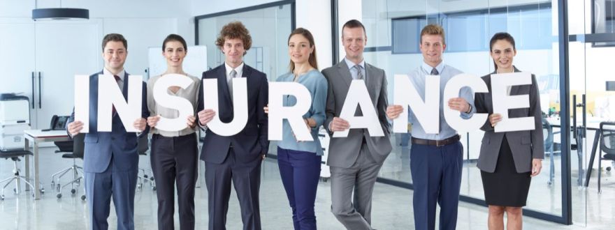 A group of professionals in a modern office holding large letters spelling 