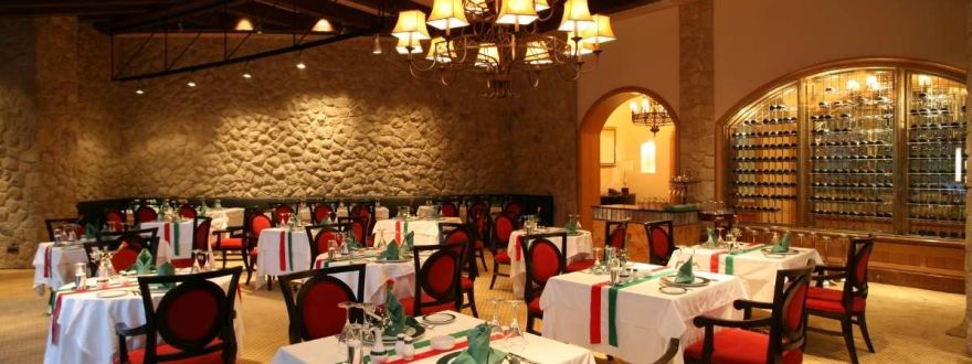 Elegant Texas restaurant interior with set dining tables, warm lighting, and stone walls.