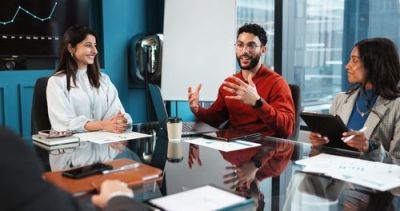 Diverse business professionals meeting around a conference table in a modern office.